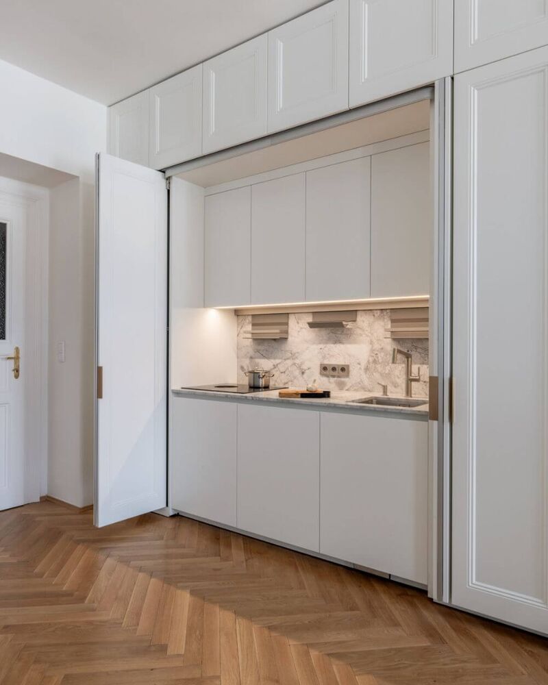 La cocina Eggersmann cuenta con paneles lacados en blanco mate combinados con cuarcita Bianco Nuvola.